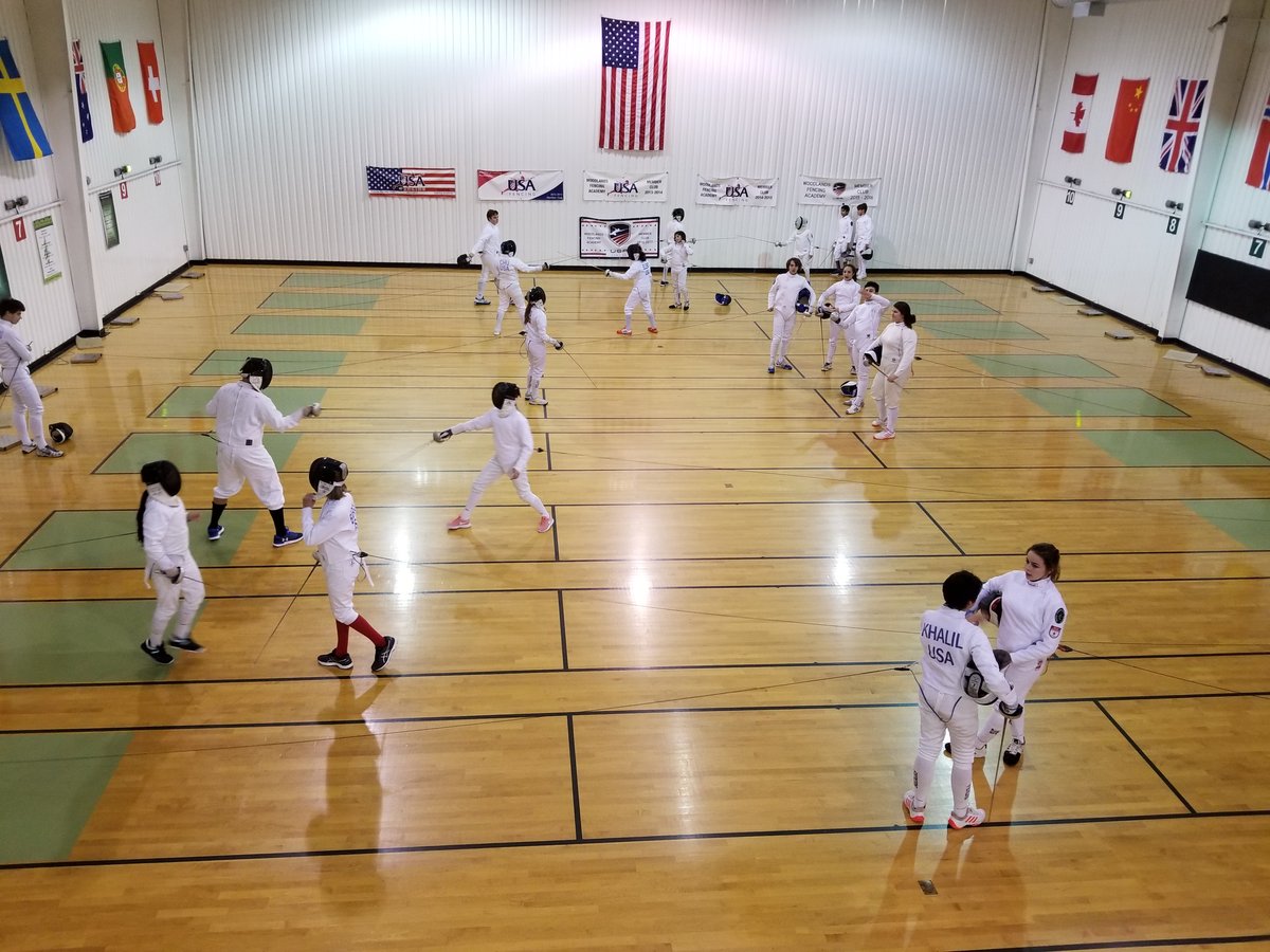 Young fencers in full protective equipment at the salle