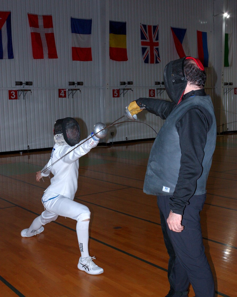 A young fencer taking an individual lesson